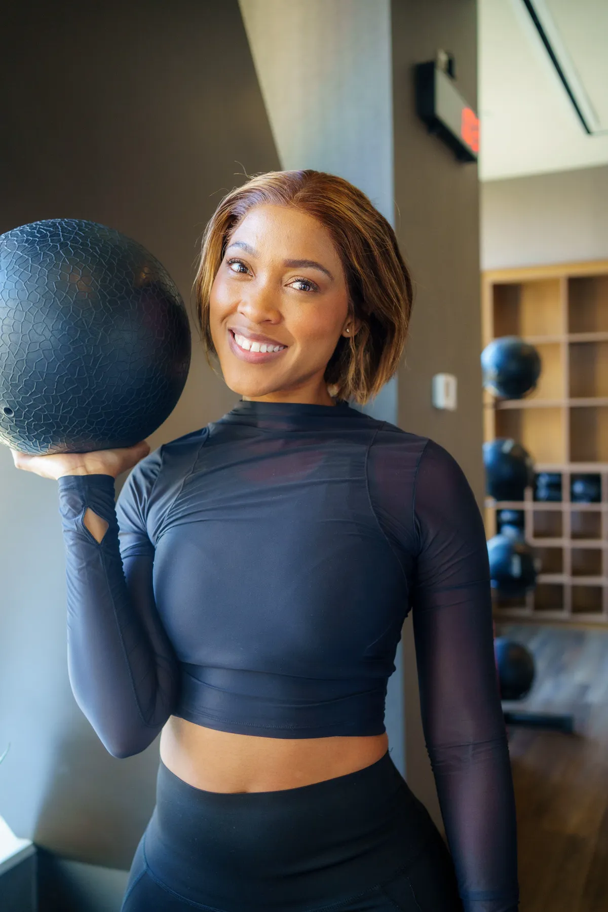 Coach Rea holding a medicine ball in the gym