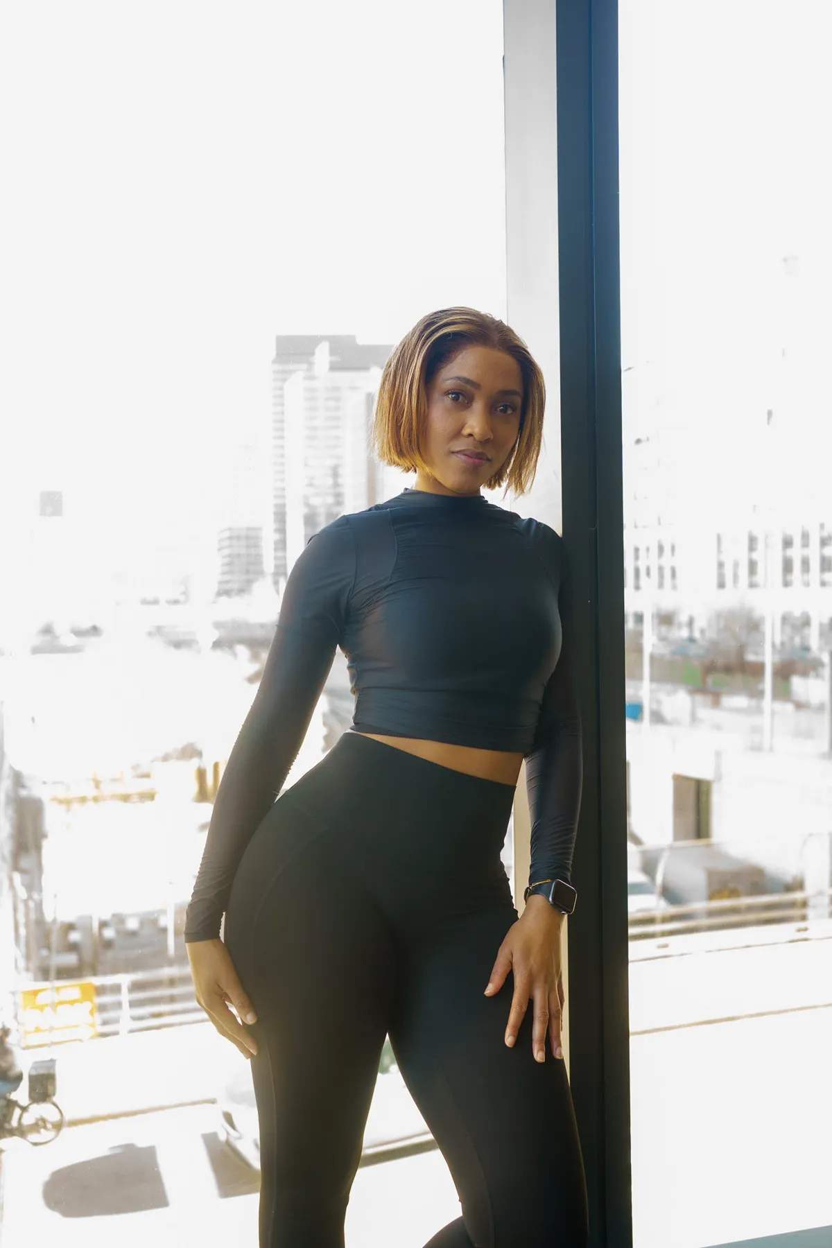 Coach Rea by a sunlit window overlooking the city